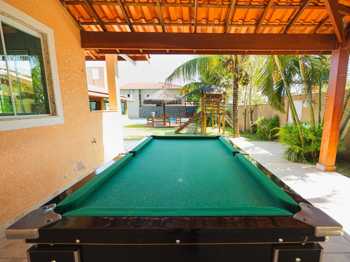 Mesa de bilhar na área coberta com vista para a piscina