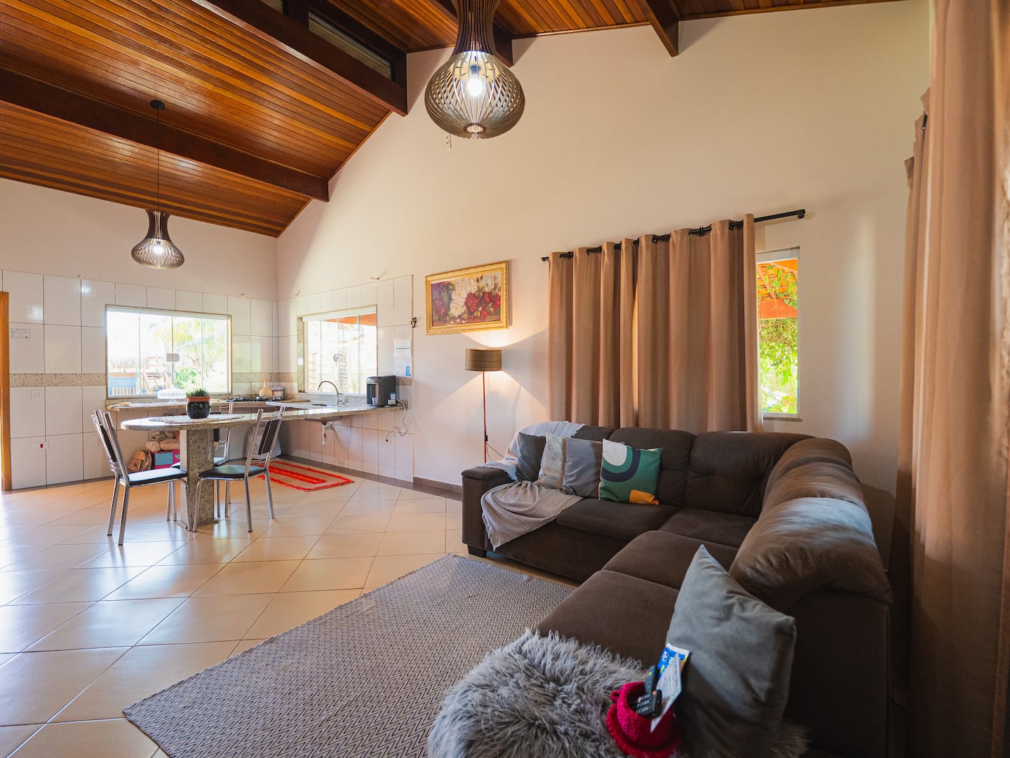 Sala de estar da casa térrea com pé-direito alto e forro de madeira